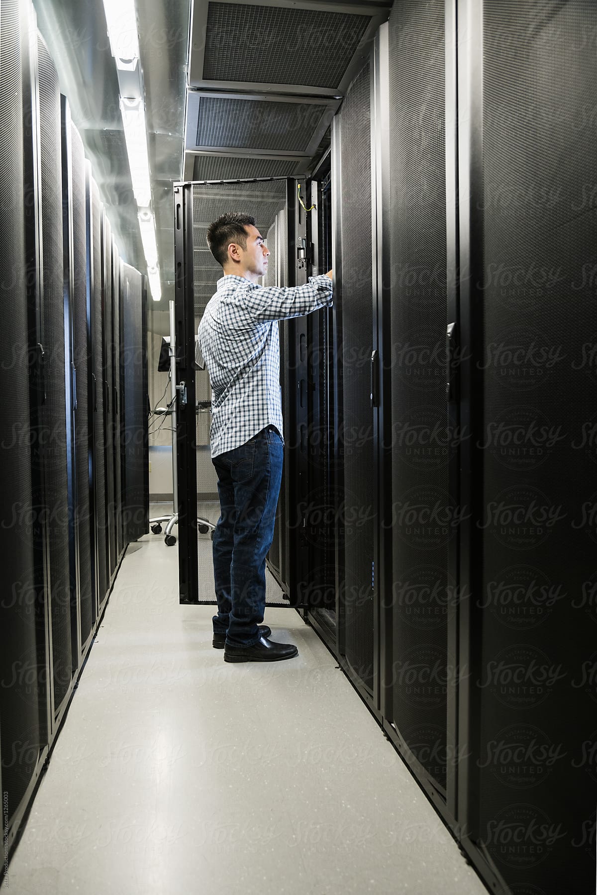 Vertical shot of technician working on a server in a cabinet in