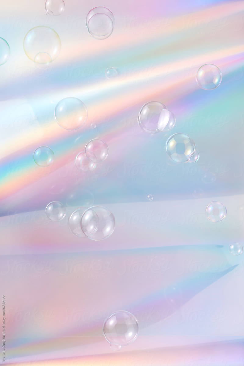Transparent bubbles on background with iridescent gradient.