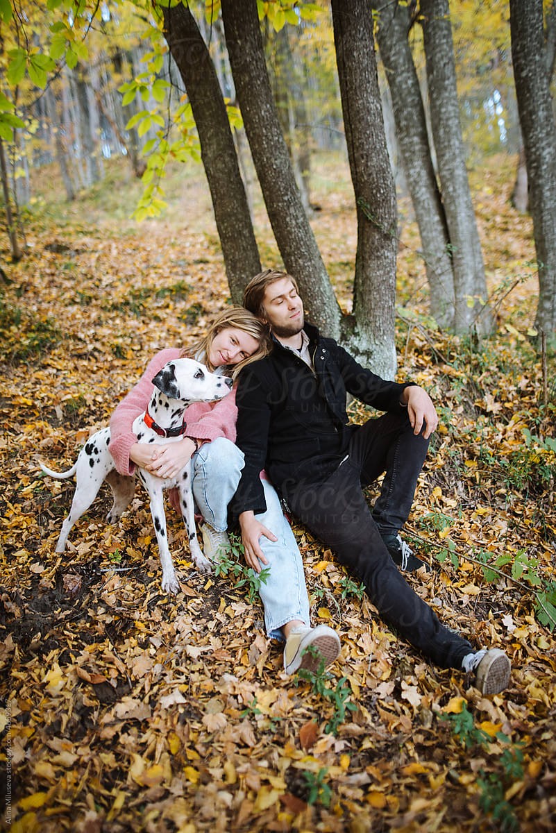 Content couple with cute dog in autumn park
