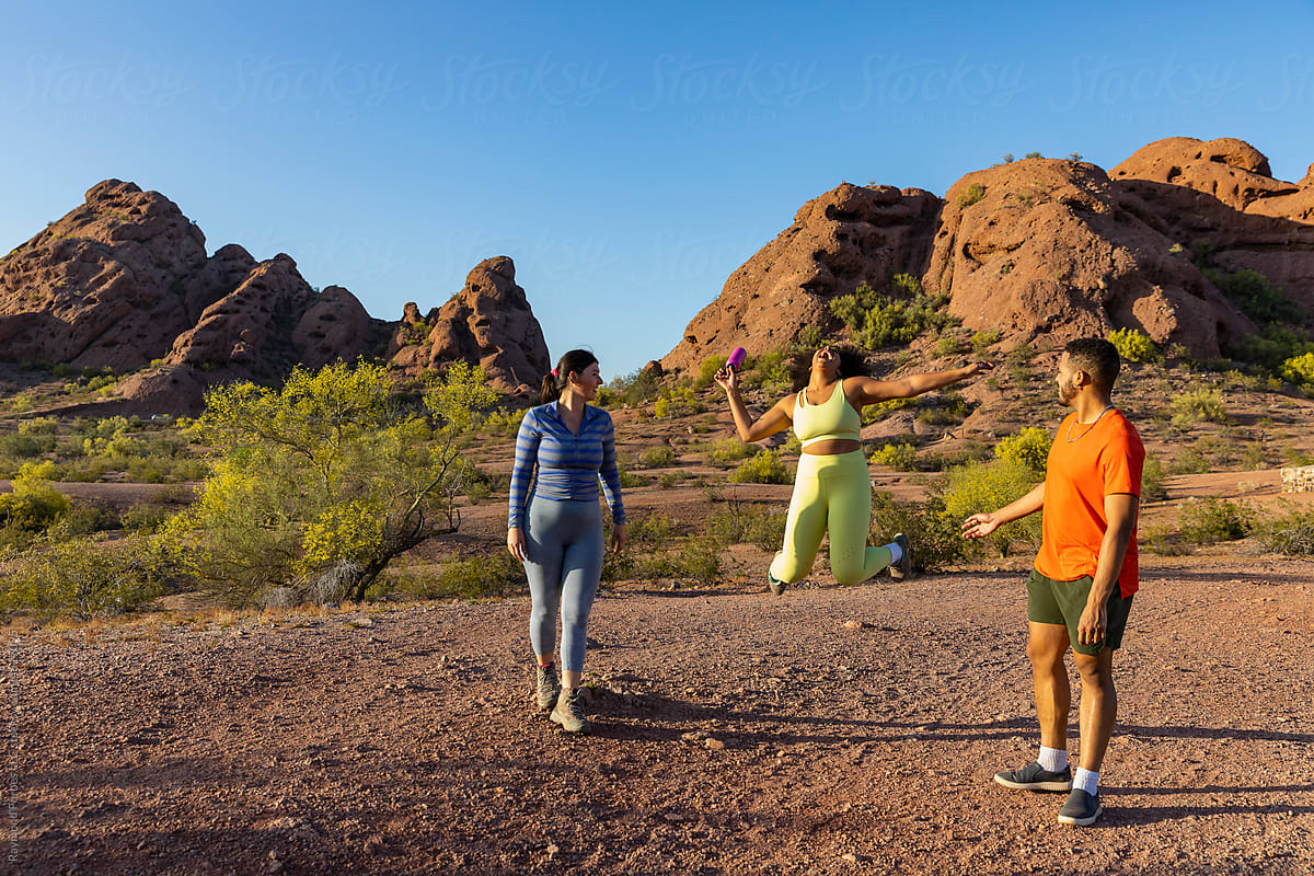 Girl jumps during hiking trip  together in Arizona Desert landscape