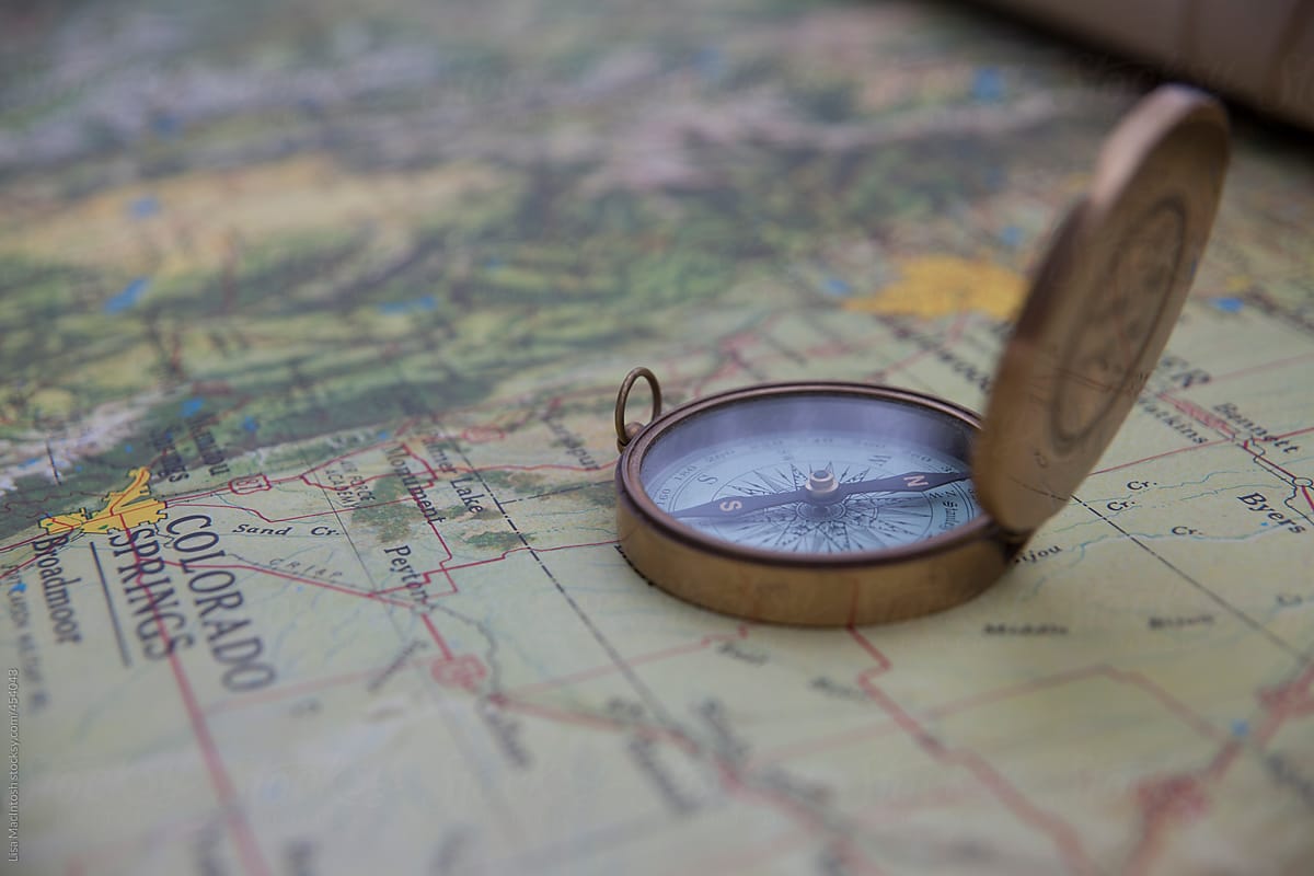 brass compass sitting on vintage American map