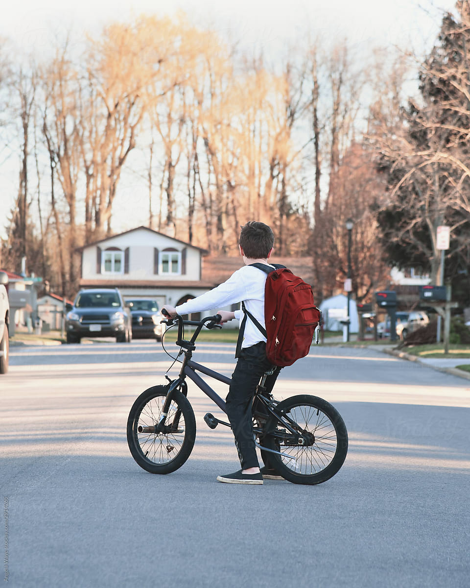 School Boy on Bicycle Looking Down Street