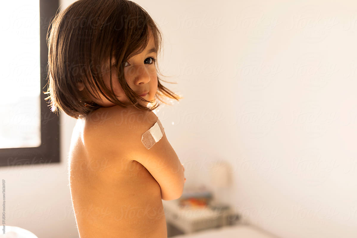 little girl gently cradling herself after vaccine