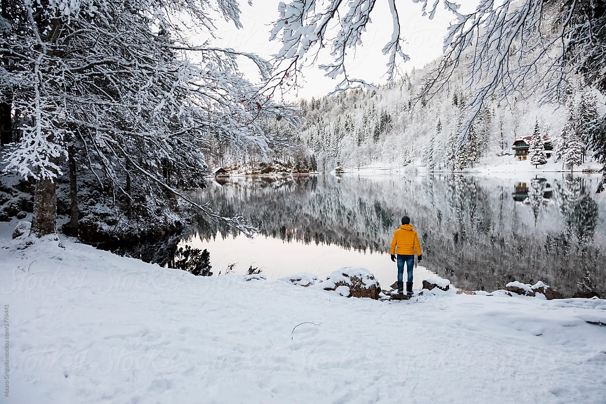 Man looking to an alpine lake in winter