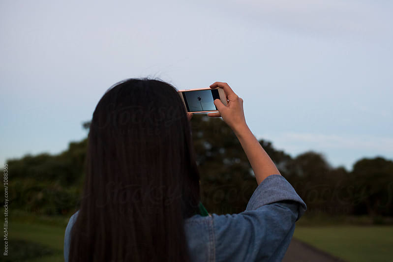 A woman taking photos in Sydney with her smartphone