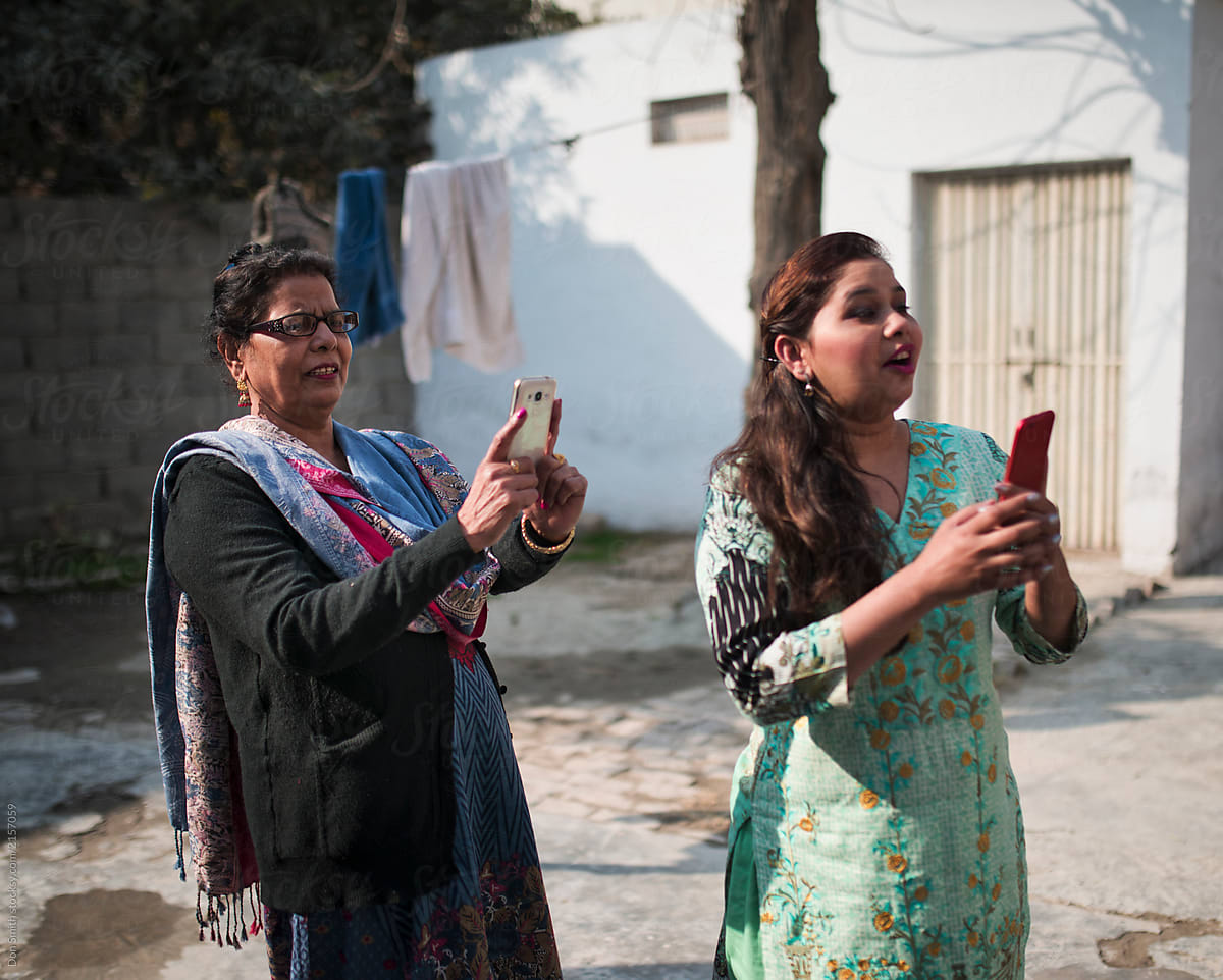 Mother and daughter in law using phones to take pictures, Punjab, Pakistan