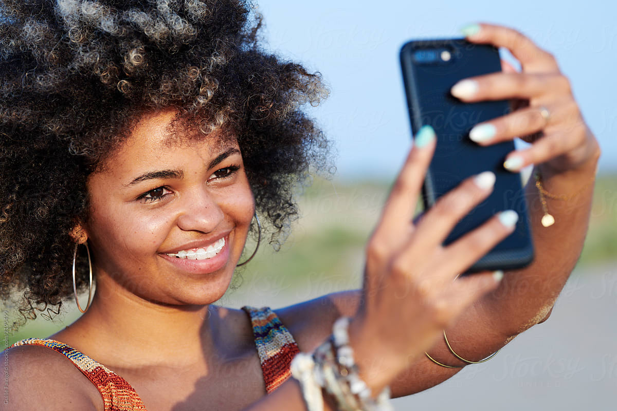 Pretty woman taking selfie via cell phone.