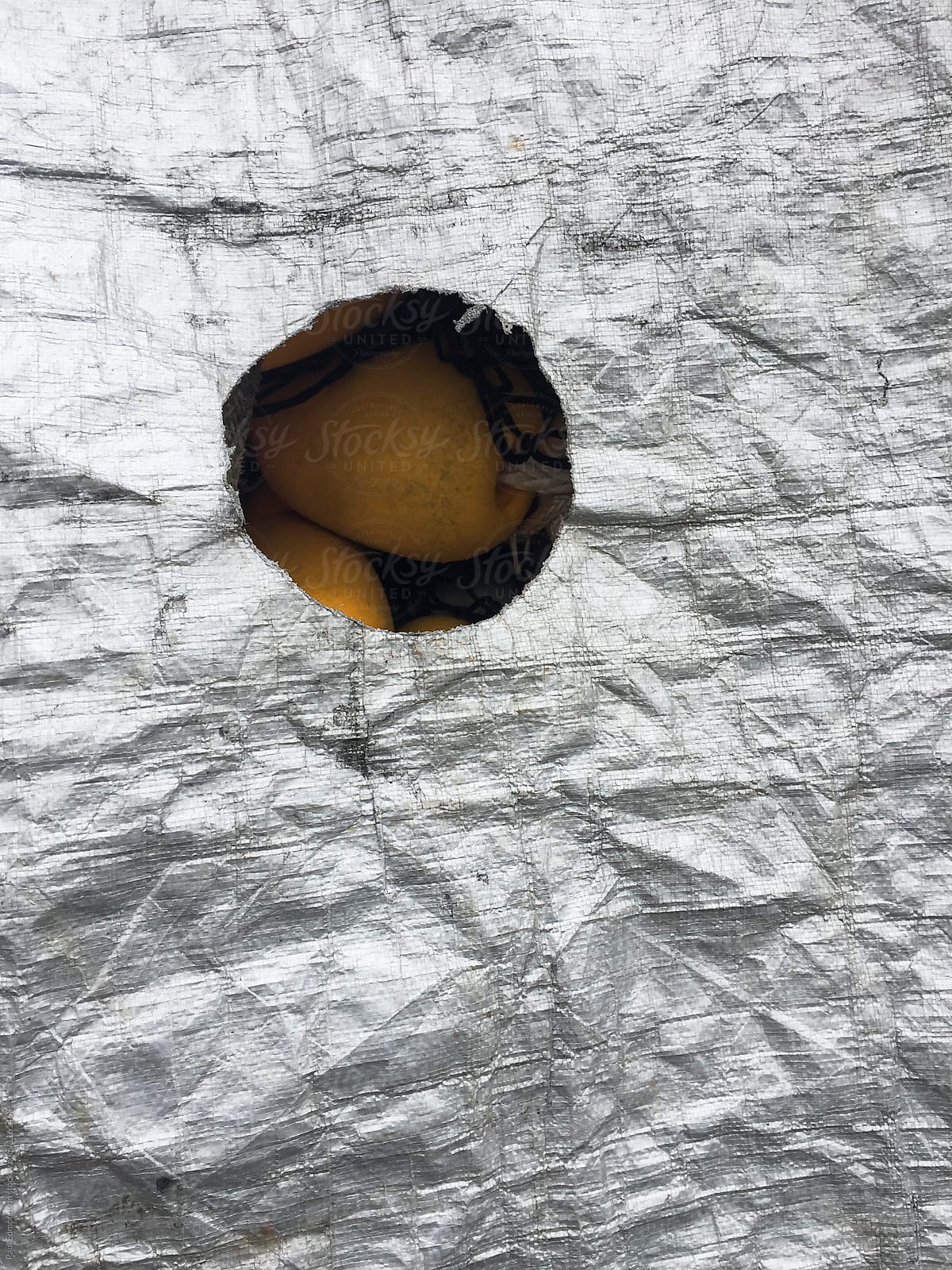 Hole shaped opening on silver tarpaulin