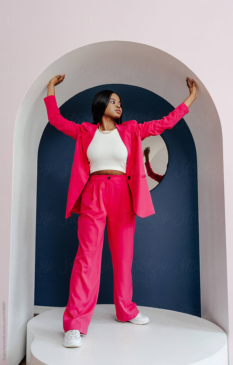 Stylish African American female model in trendy pink suit