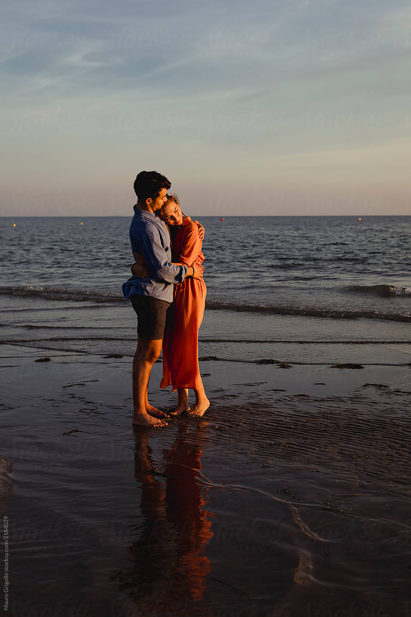 Couple embracing at the beach at sunset