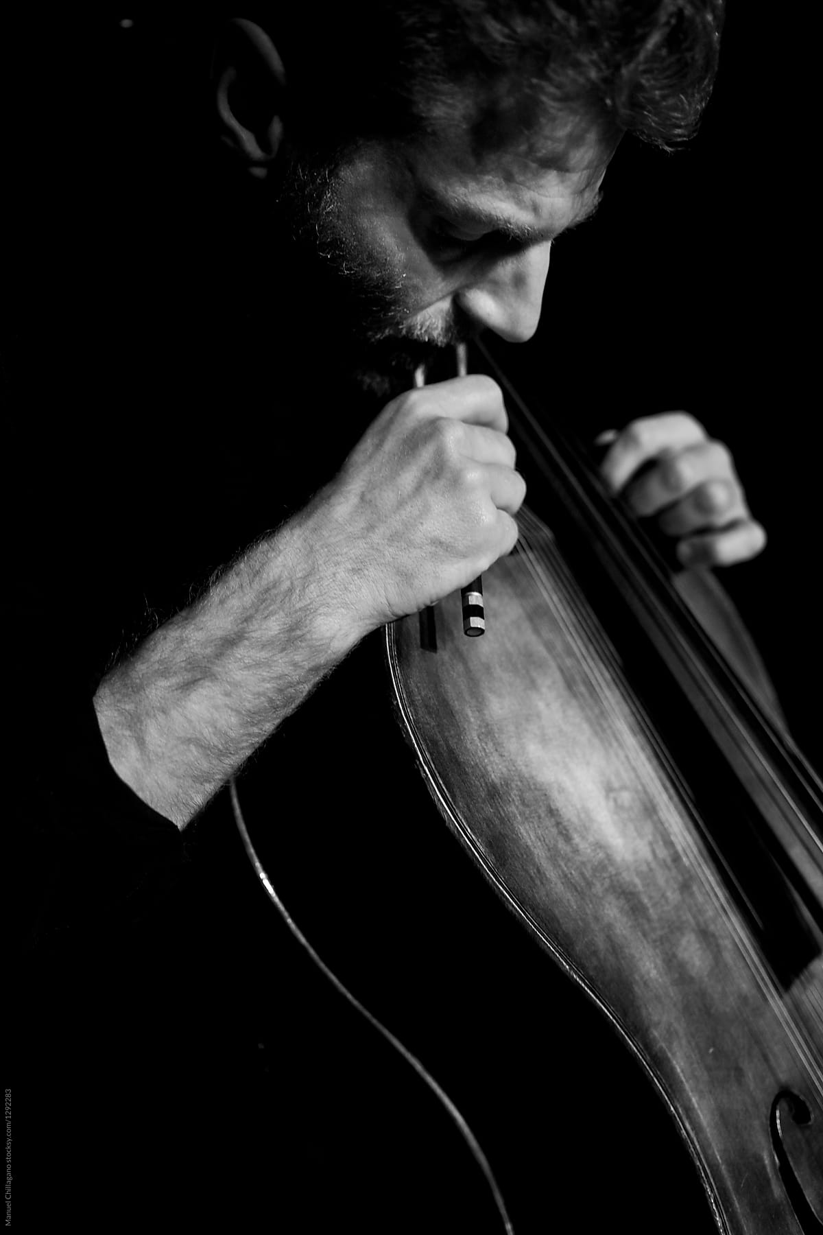 Black and White portrait of a cellist carefully playing his instrument