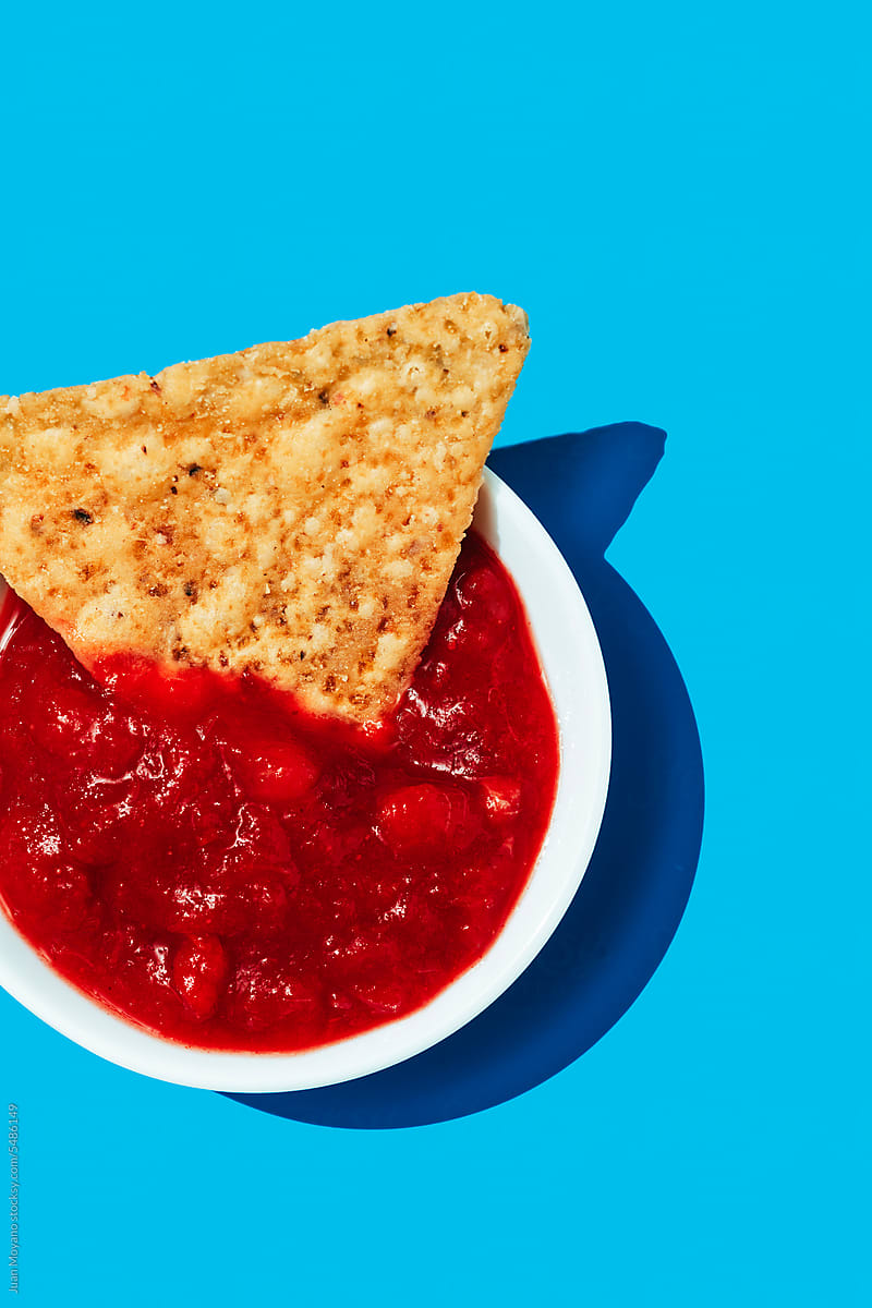 tortilla chip dipped in a tomato-based salsa