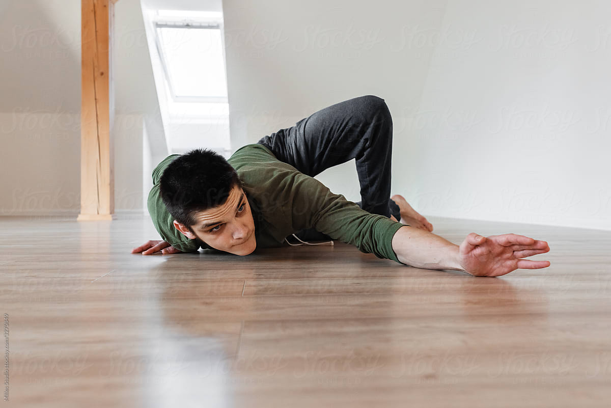 Flexible guy pressing against floor during dance