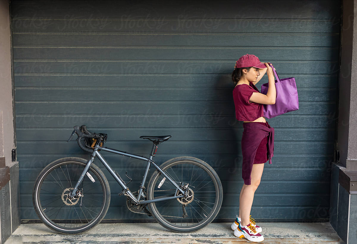 girl puts on a cap near the bike