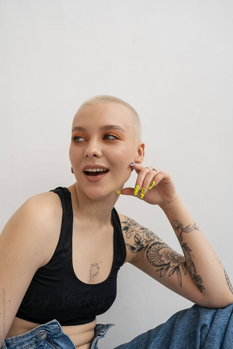 Cheerful informal young woman with short hair and tattoo