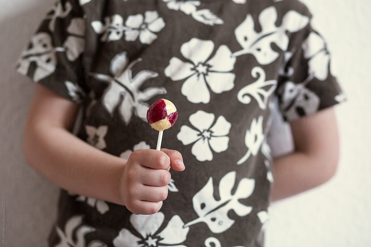 Boy holding lollipop, closeup