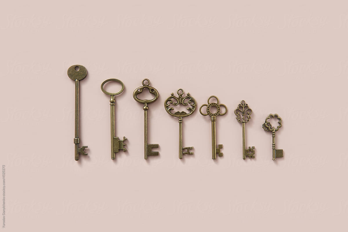 Vintage ornate keys of various size on beige background