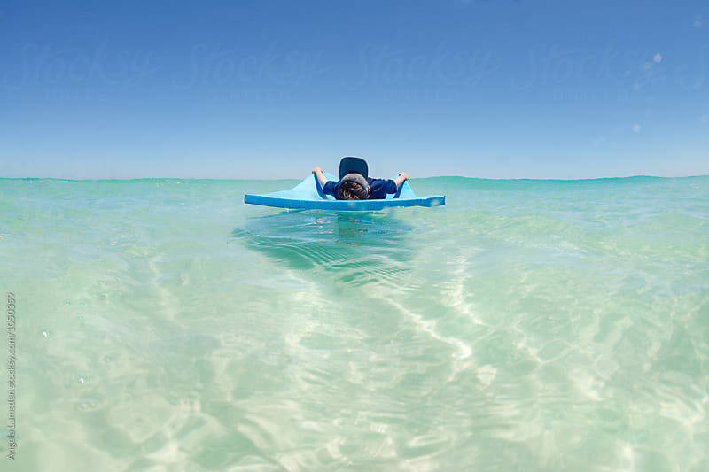 Relax - floating on a large mat in the clear water of the Indian Ocean in summer