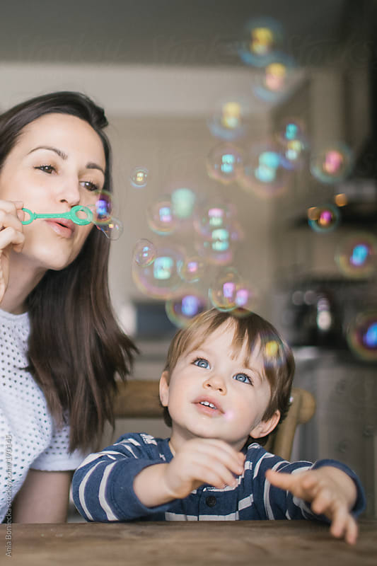 Mom blowing bubbles with her son