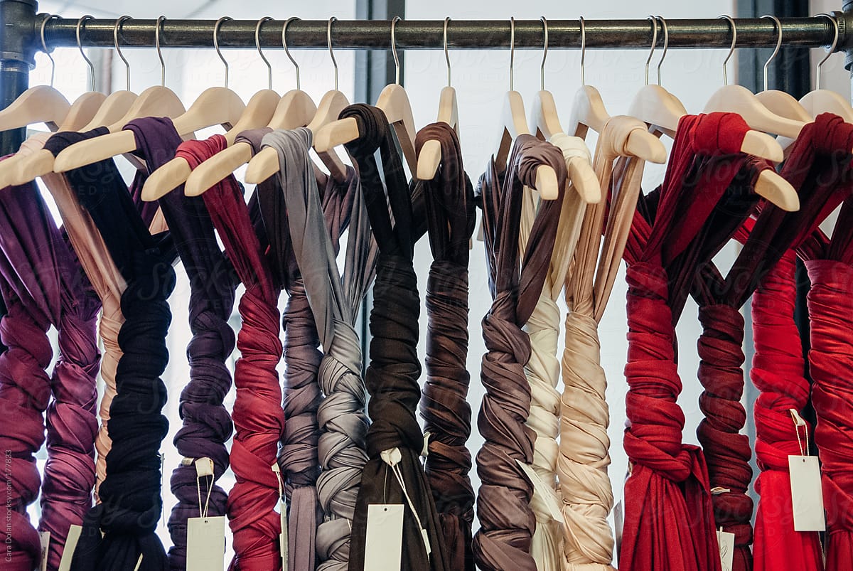 Rack of jersey cotton dresses on hangers tied up in braids