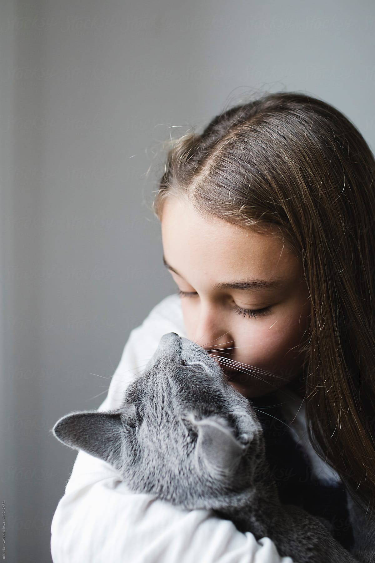 Cute little girl kissing her cat