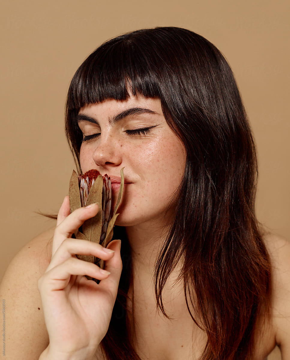 Woman smelling dried flower with calm expression