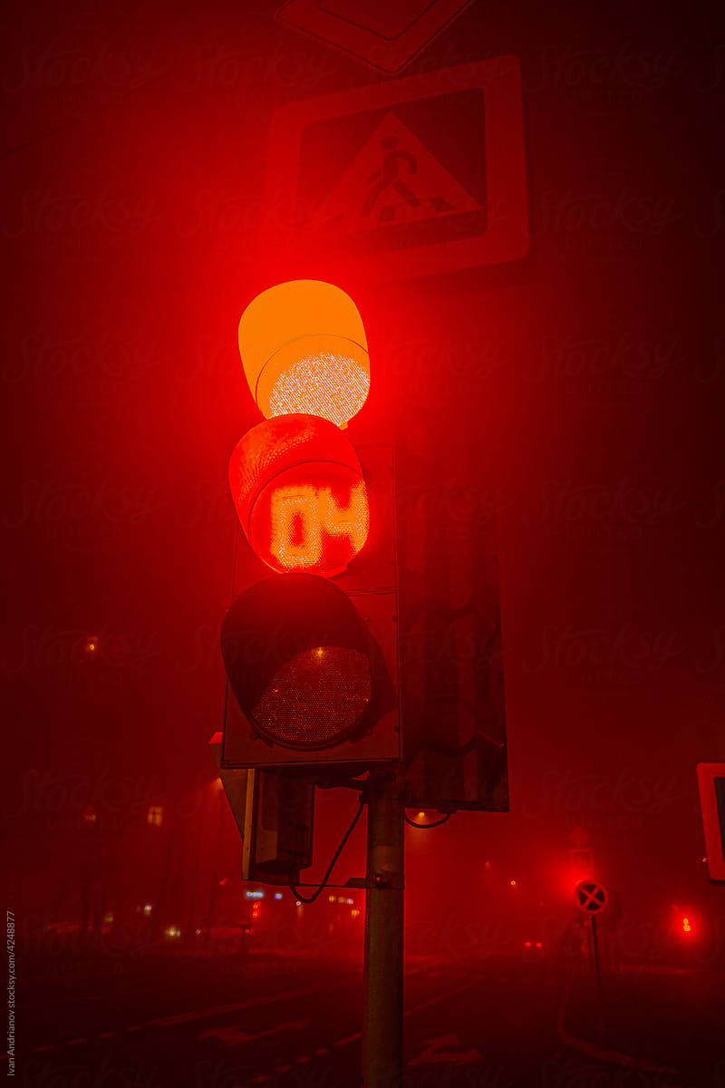 Red Traffic Light Signal On City Street At Night