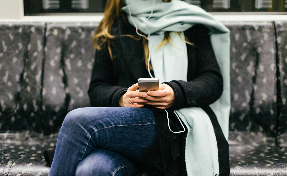 Woman sitting in Subway Train using Smartphone