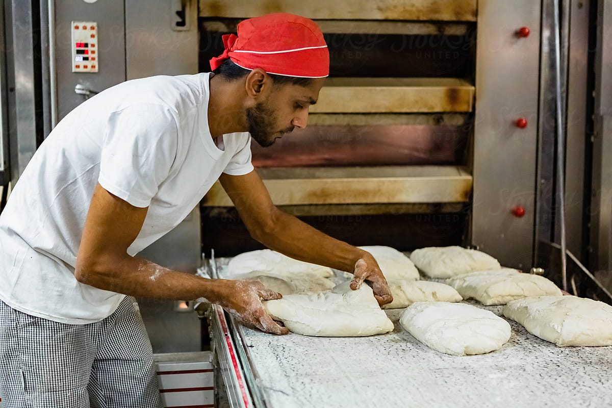 Baker Arranges Bread Dough to Bake in the Oven