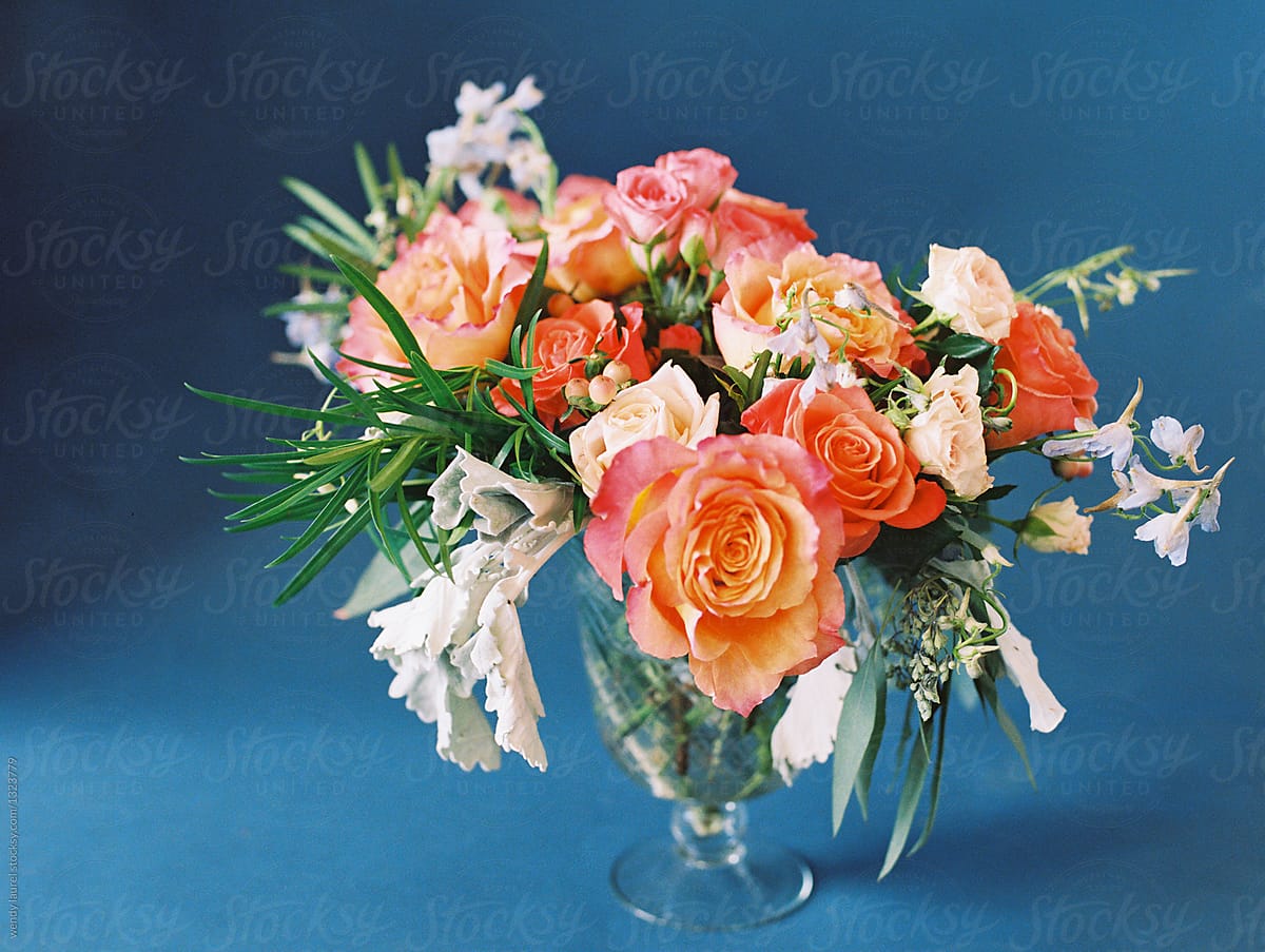orange and peach floral arrangment with green ferns