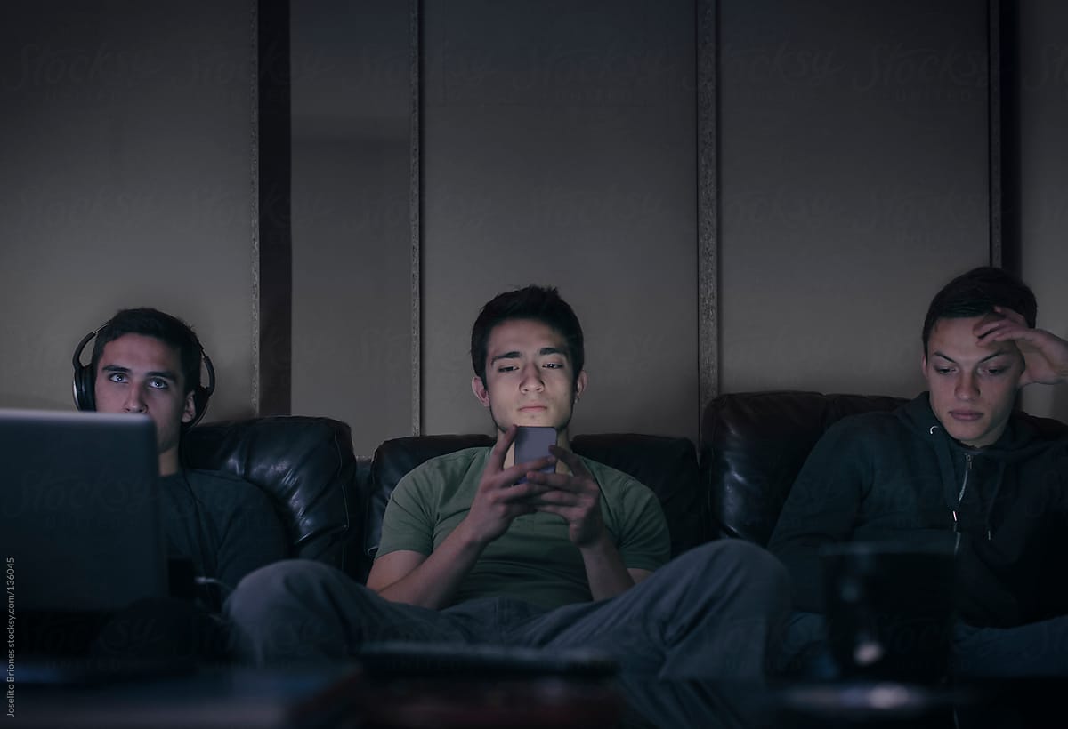 Student Friends and Rommates Watching TV together and Using Smartphones and Laptop