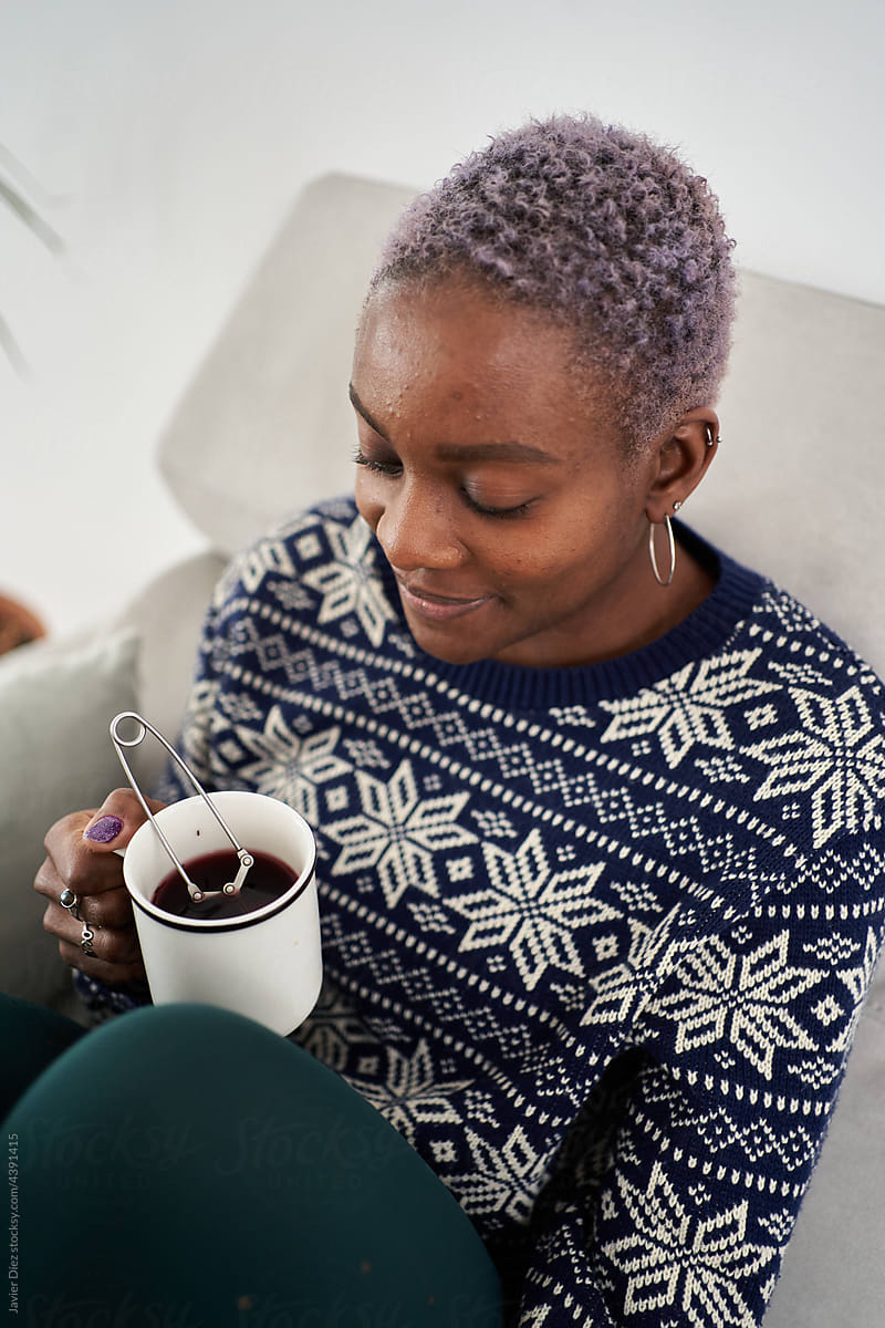 Woman enjoying hot drink on couch