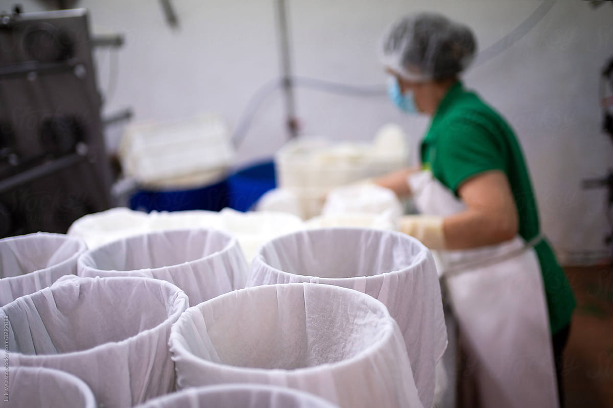 Woman With Mask Working In The Cheese Factory.
