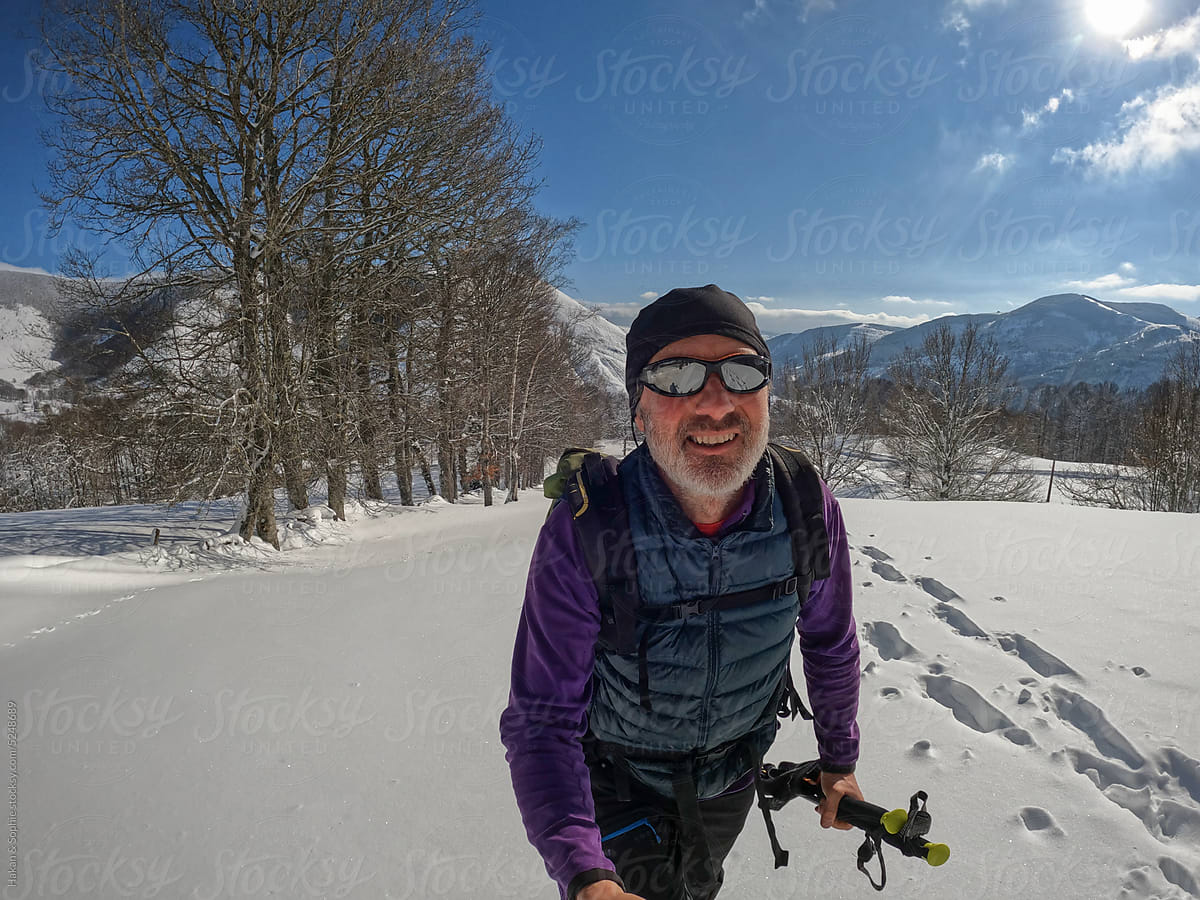 selfie of a happy mature man waling in deep snow