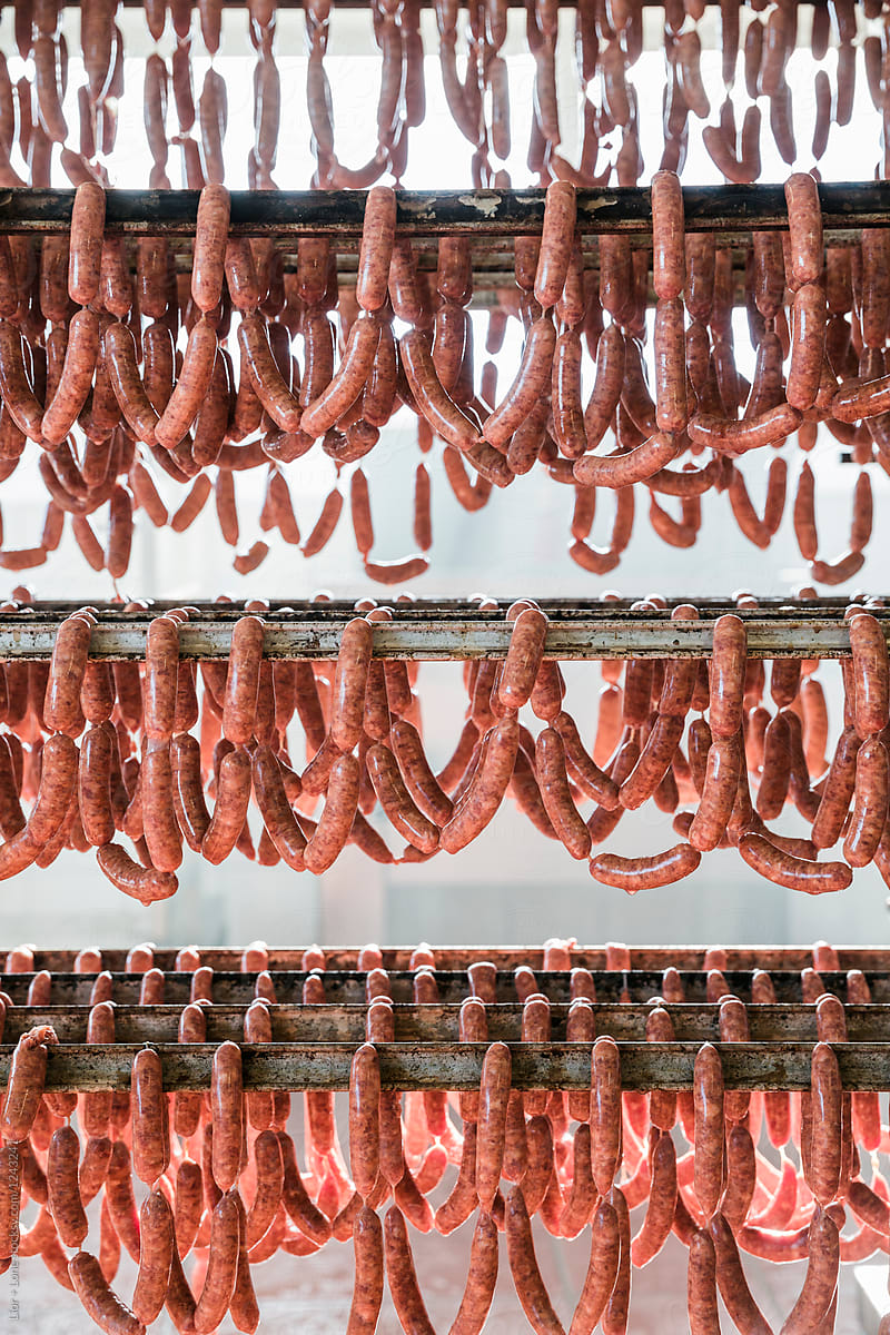 Hundreds of linked sausages hanging on mobile rack