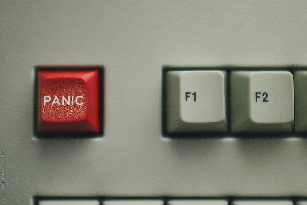 A red panic button on an old beige keyboard