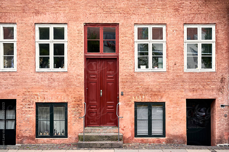 Residential house with red wooden door and windows