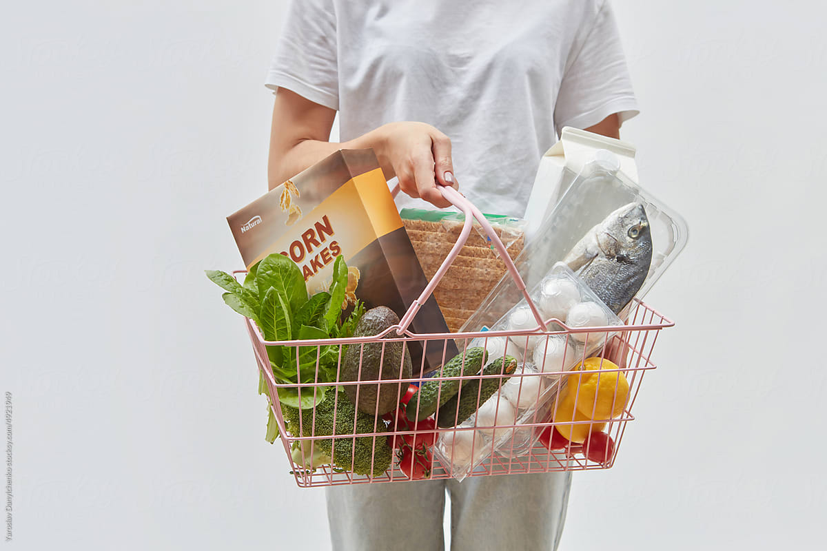 Shopping basket filled with food held by woman.