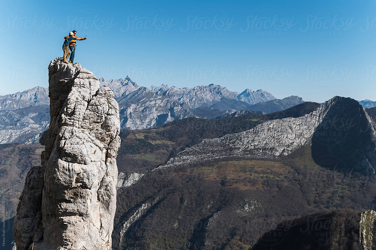 Climbers taking selfie on top of pinnacle