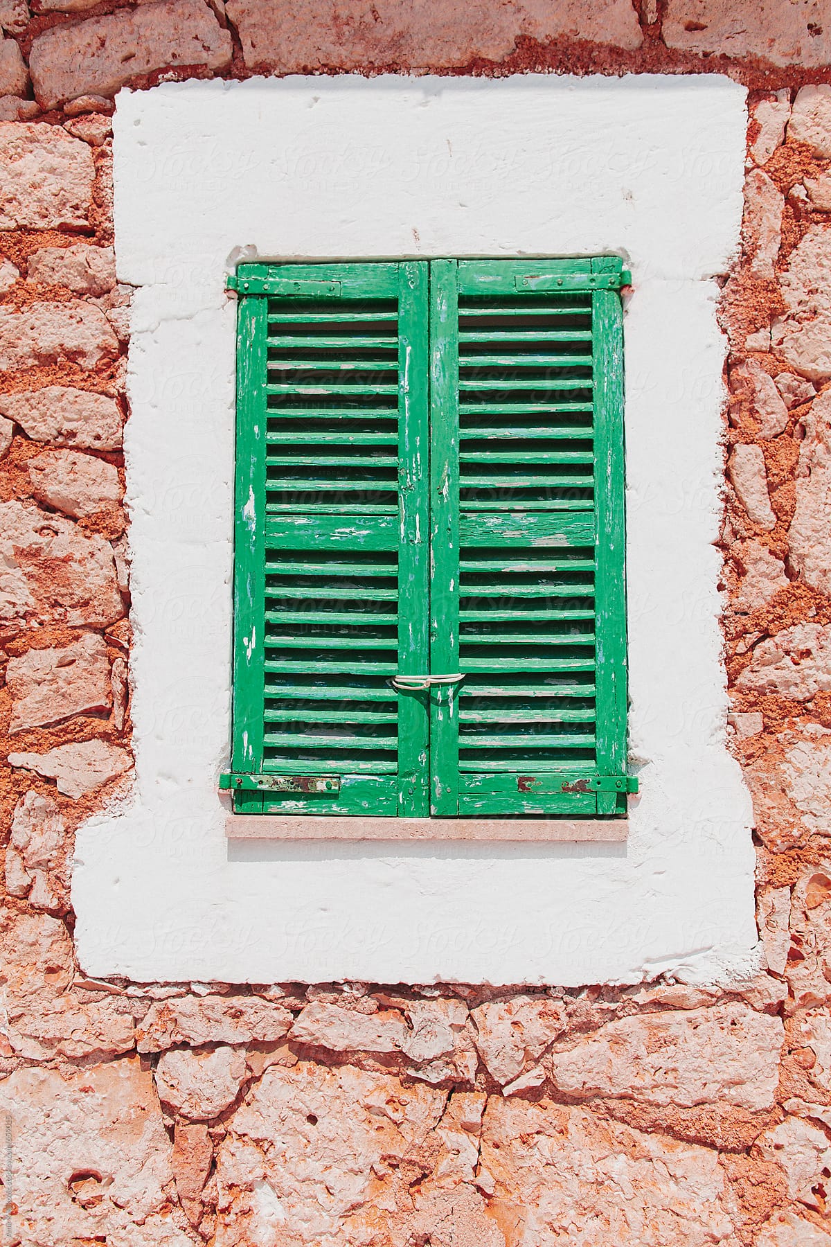 Window with colorful green wooden shutters