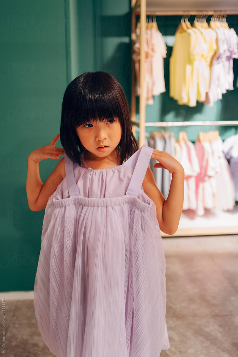 Little girl trying on dress