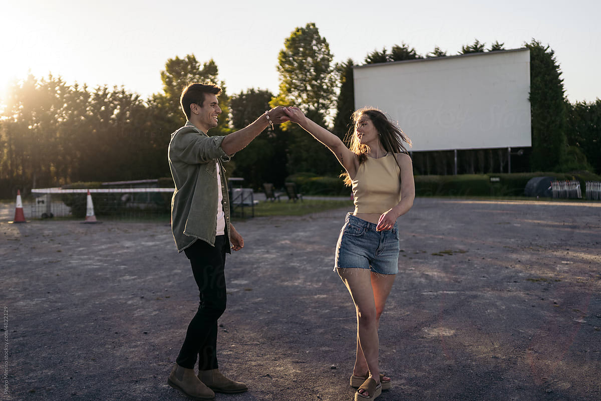 Couple dancing at sunset at the drive-in cinema