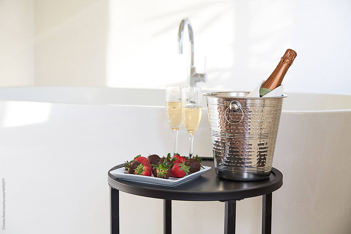 Romantic champagne and strawberries in front of bathtub