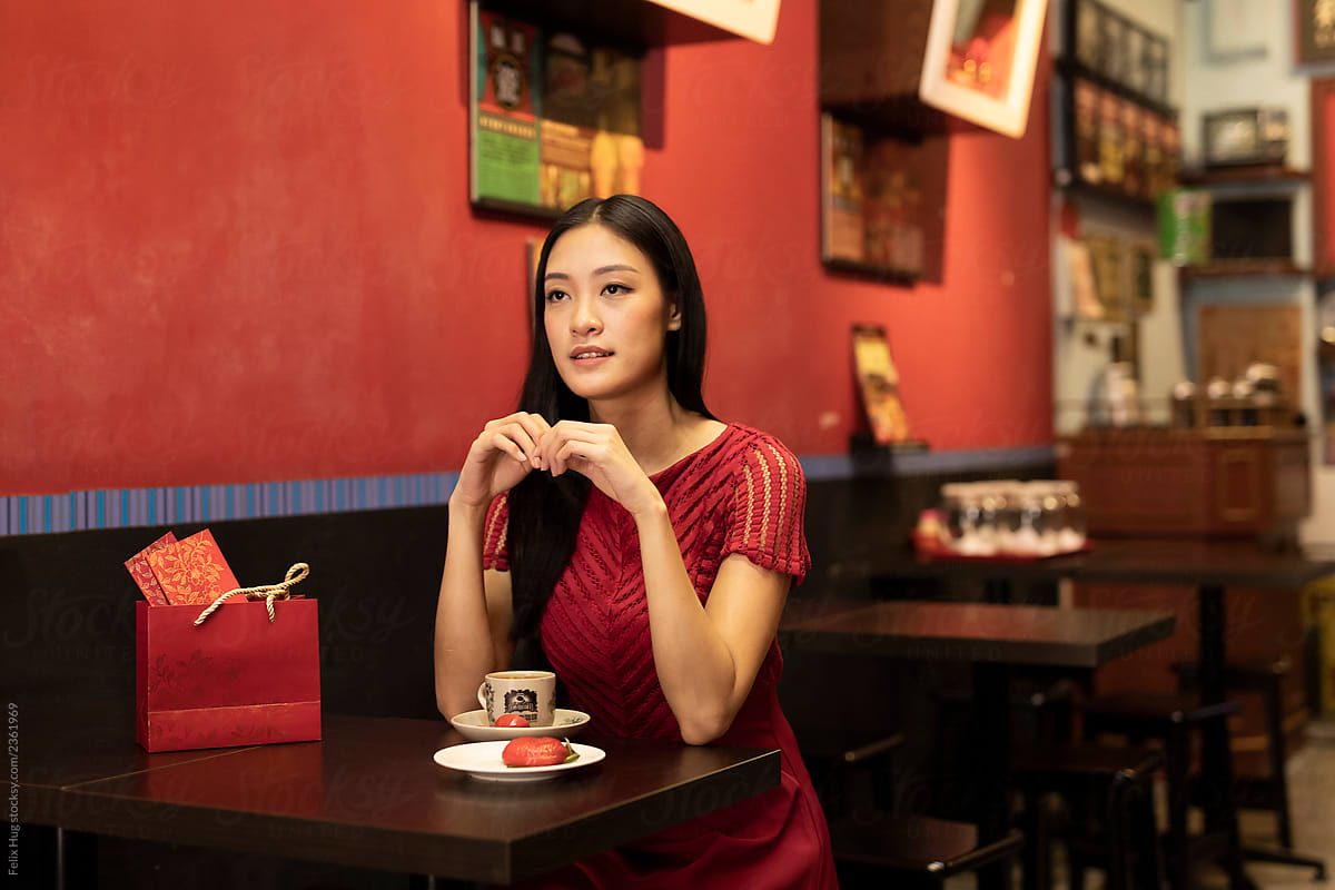 Young woman dressed in red over Singaporean coffee