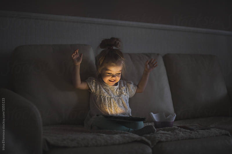 Little girl with tablet in a dark room