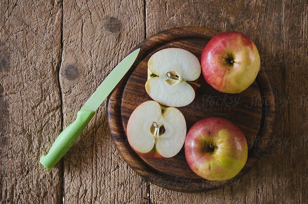 Apples arranged on a wooden plate