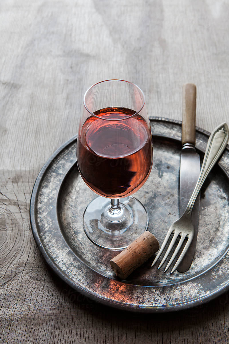 Glass of rose wine with plate, fork and knife
