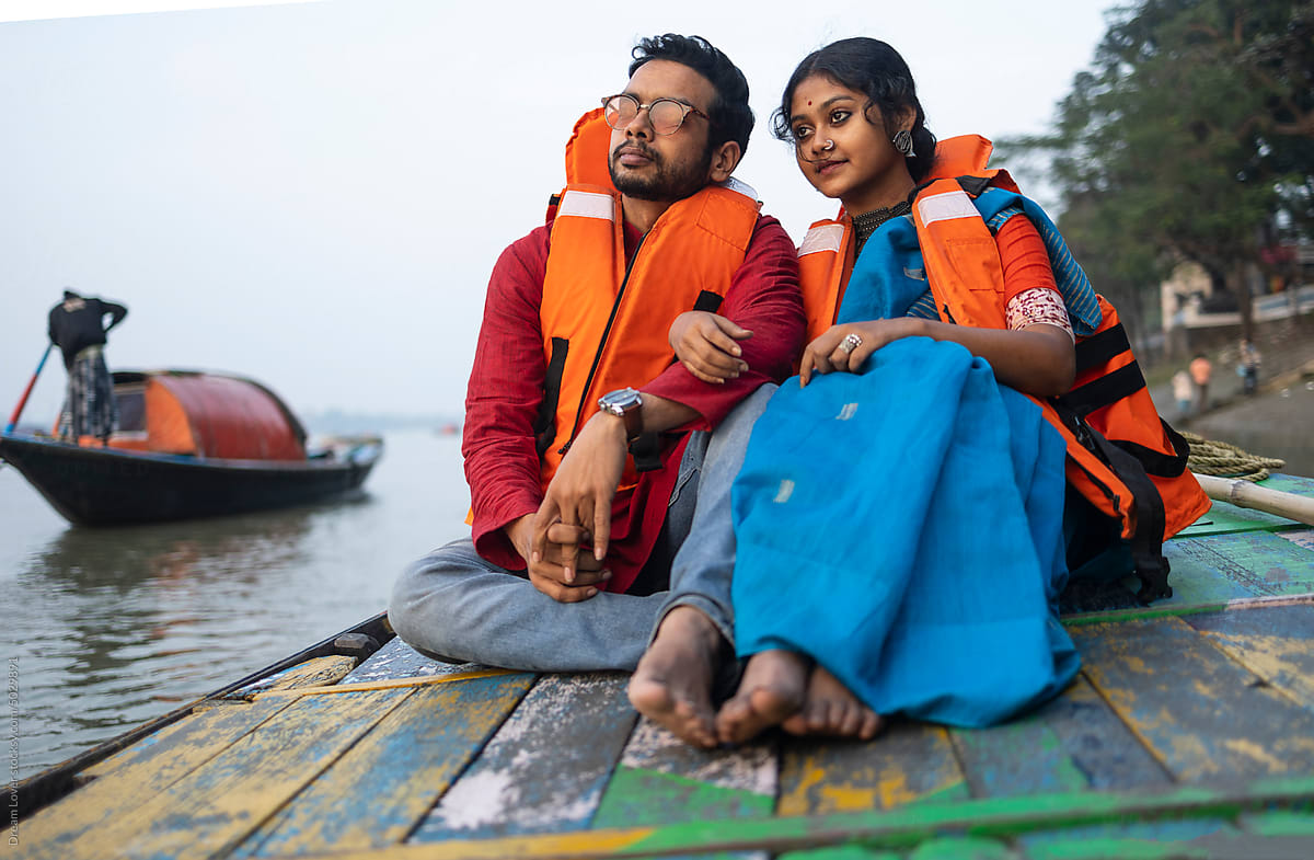 Young Couple Enjoying Travel Sitting On A Boat Over River Ganga,India