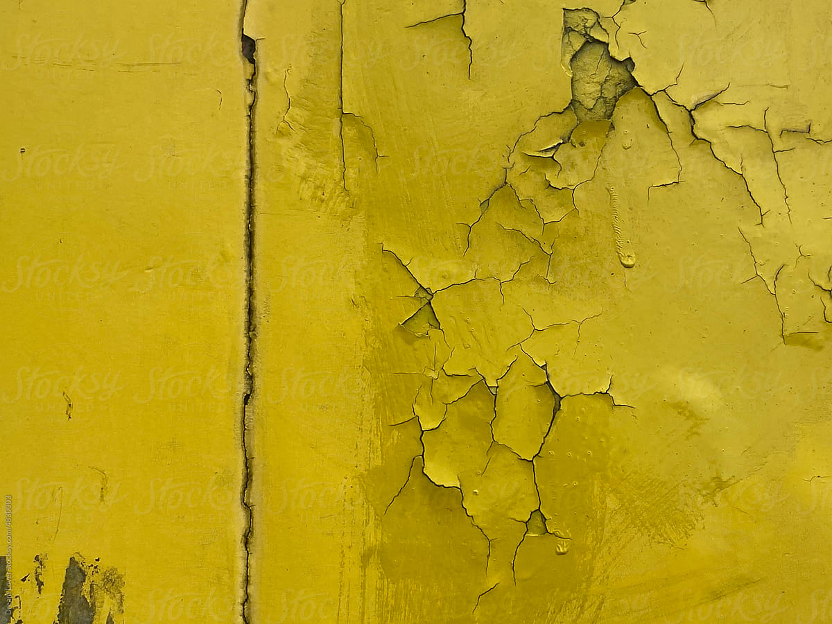 Cracked yellow color background on metallic surface