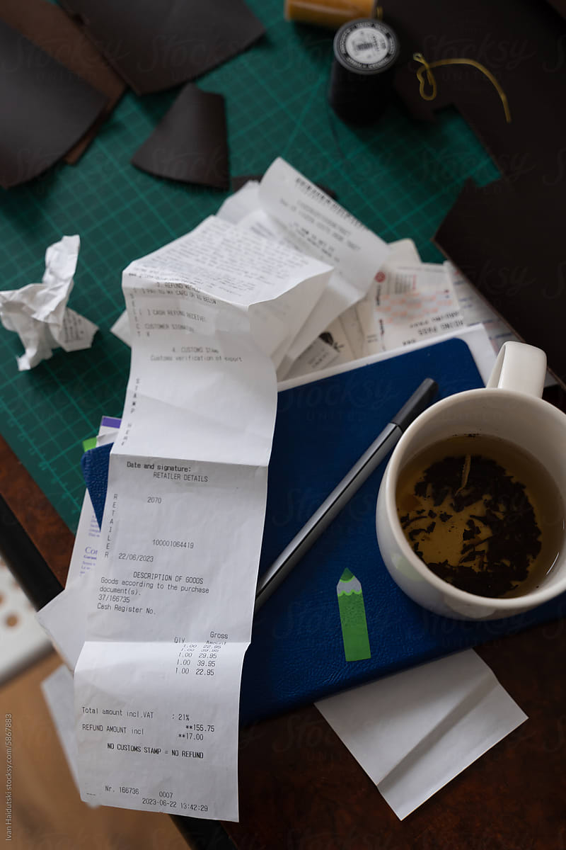 creative workspace of leatherworker filled with receipts and tools.